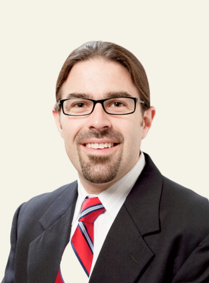 Photo of Dr. James McPartland, a white man with brown hair, goatie, glasses, and a black suit